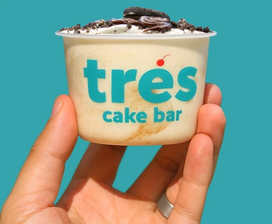 A hand holding up an Oreo tres leches cup
