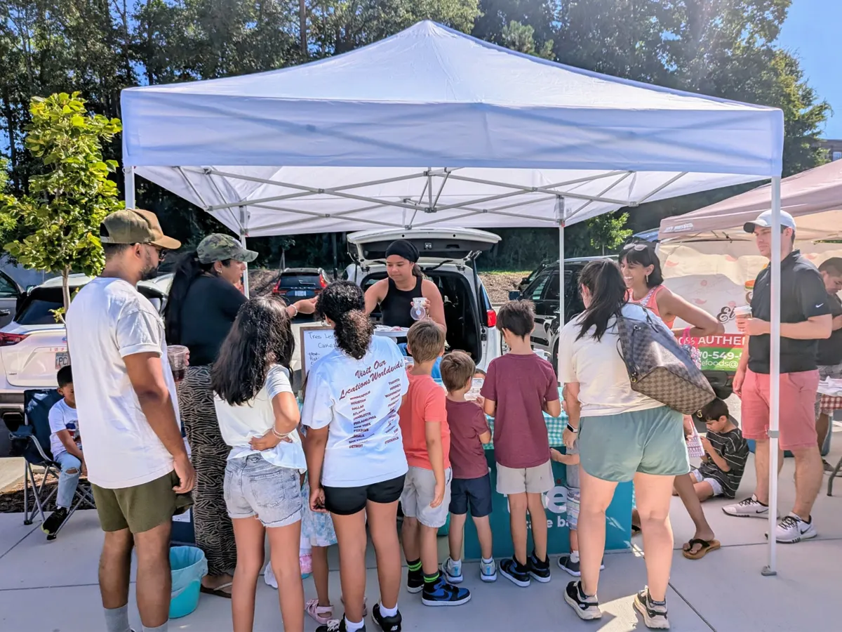A line of customers at the Tres Cake Bar tent at a farmers market